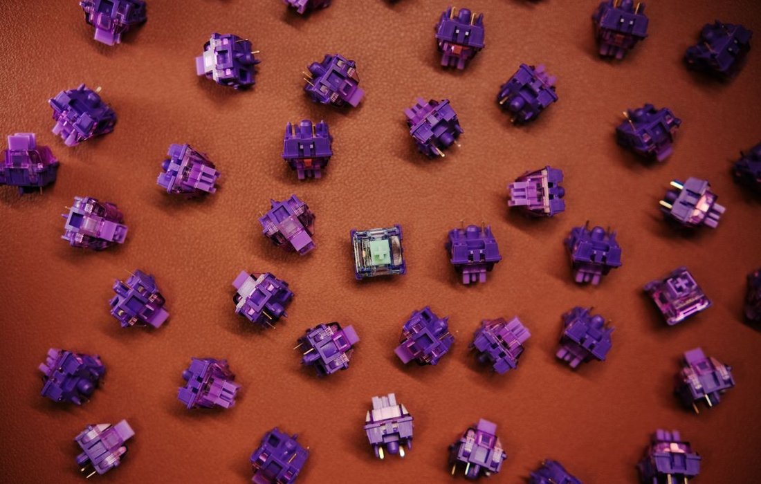 Close up of purple mechanical keyboard switches showing switch types