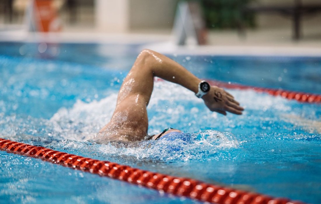 Swimmer wearing a watch in a pool demonstrating water resistance